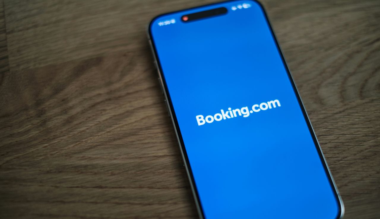 Smartphone displaying the Booking.com app on a wooden surface.