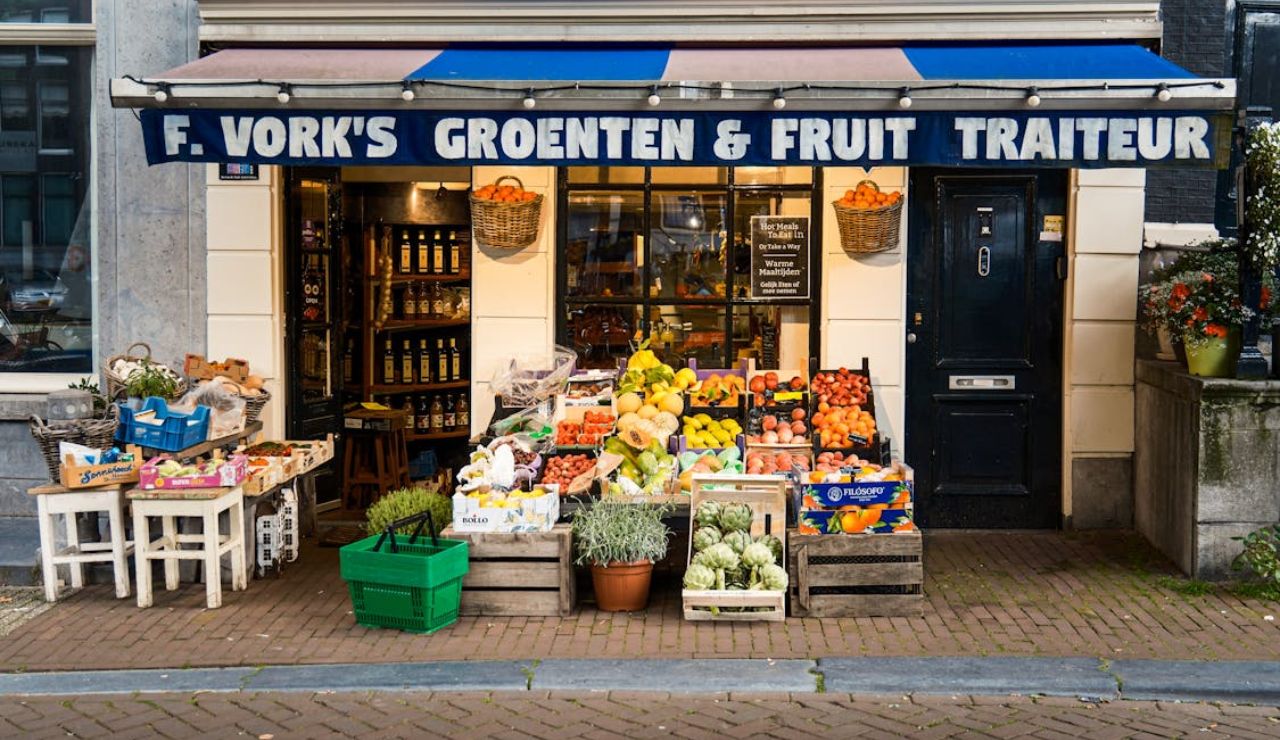 Colorful fruit and vegetable stand outside a local shop in Amsterdam, symbolizing support for local economic growth through tourism.