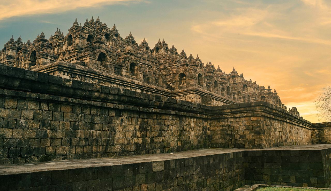 Borobudur Temple stupas with sunrise and mist.