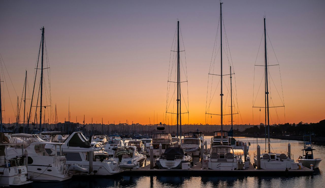 Boston harbor skyline with sailboats at sunset