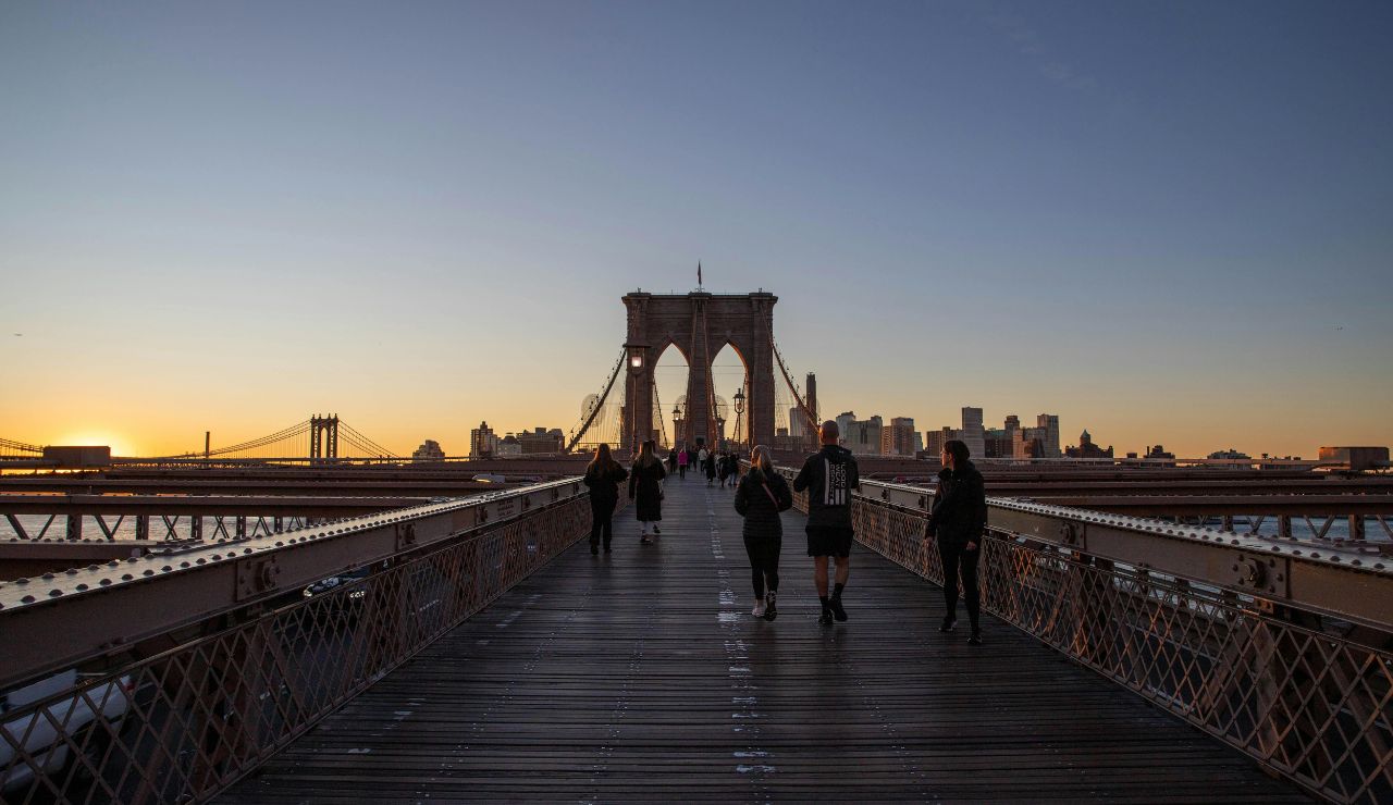 Sunset view from Brooklyn Bridge with glowing NYC skyline