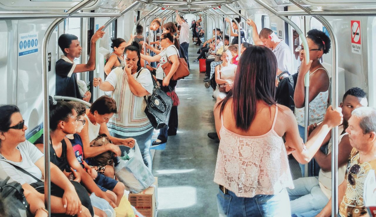 Traveler keeping a backpack on the front inside a crowded metro