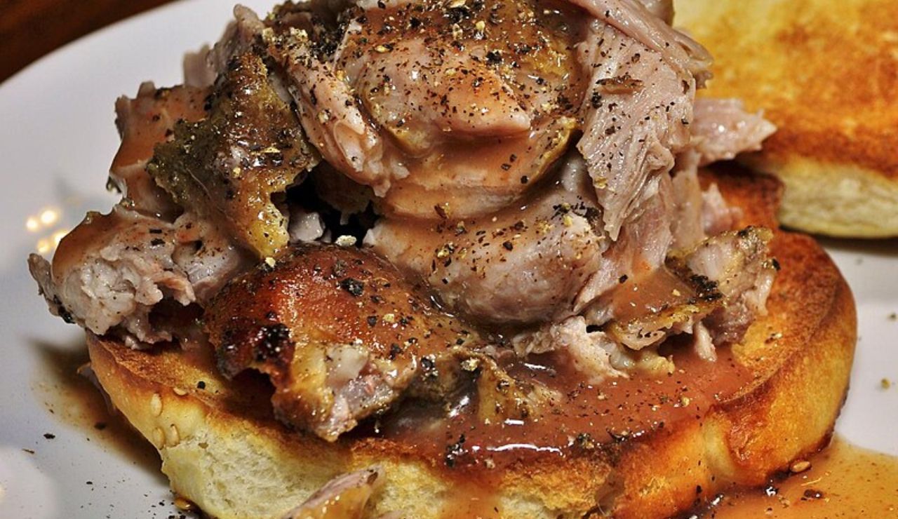 Caribbean pork sandwich from Un Bien with juicy pork, grilled bread, and savory sauce.
