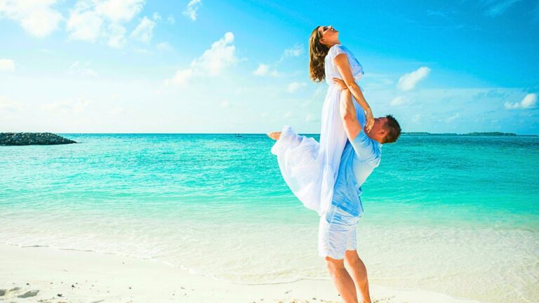 Couple standing on a quiet cliffside overlooking the Caribbean Sea