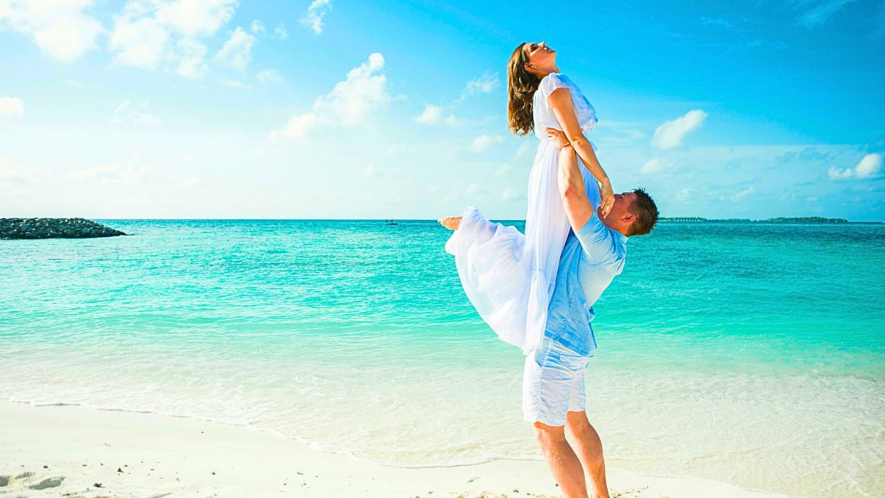 Couple standing on a quiet cliffside overlooking the Caribbean Sea