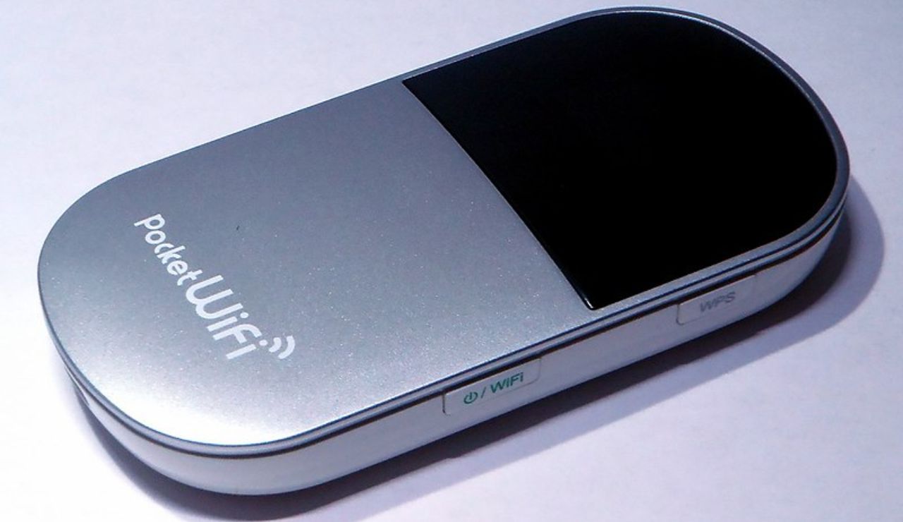 Close-up of a portable pocket WiFi device placed on a white surface.