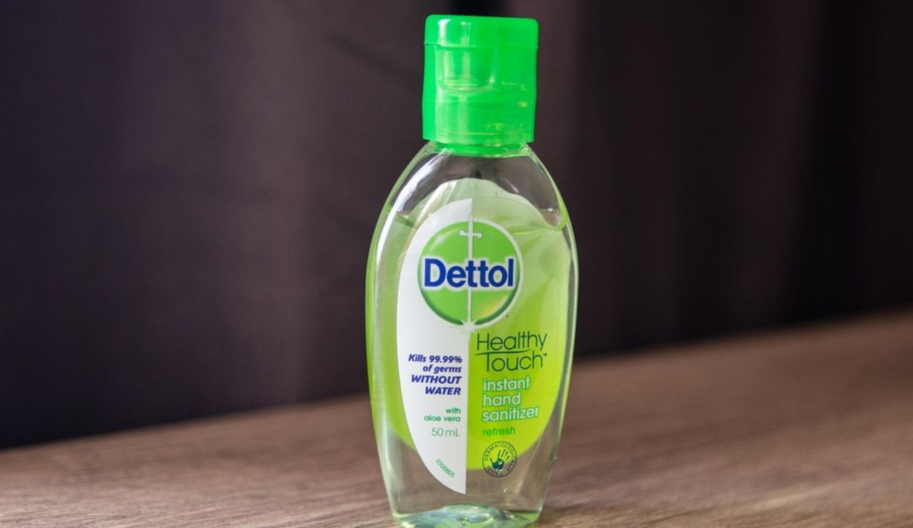 Dettol Healthy Touch instant hand sanitizer bottle with green cap placed on a wooden surface.