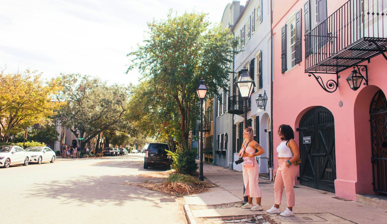 Historic pastel homes in Charleston framed by leafy trees