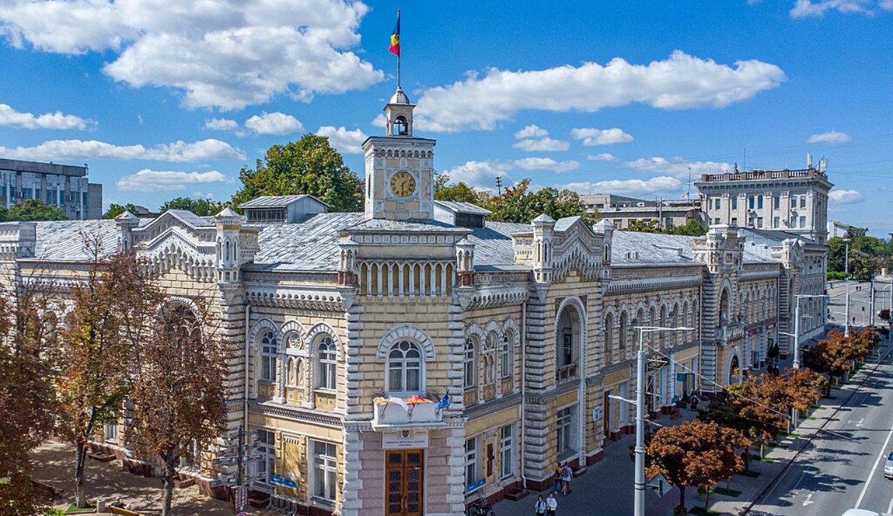 Historic city hall building in Chișinău, Moldova, with ornate architecture, a clock tower, and the Moldovan flag flying on top.