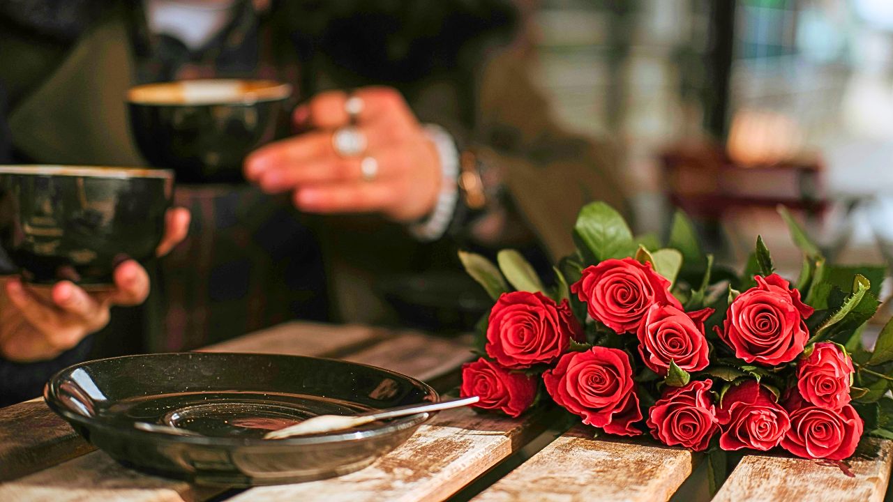 Couple enjoying coffee at a Milan café with the Roses on the Table.