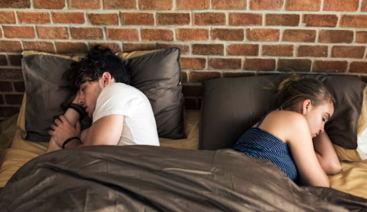 Tired couple relaxing separately in a hotel room