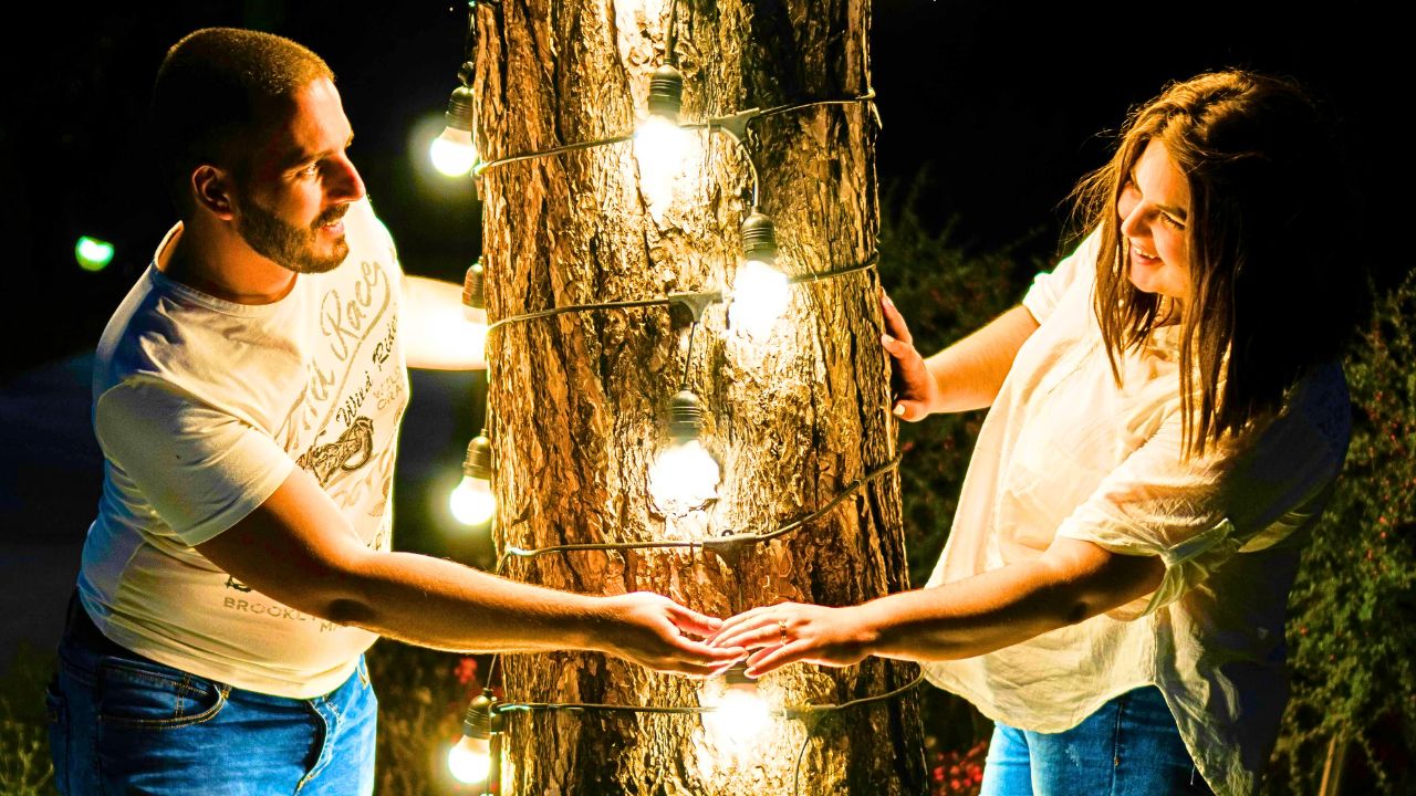Couple strolling hand-in-hand under glowing city lights at night