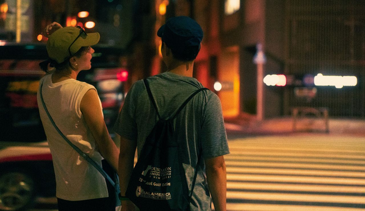 Couple slowly walking through city looking tired but happy