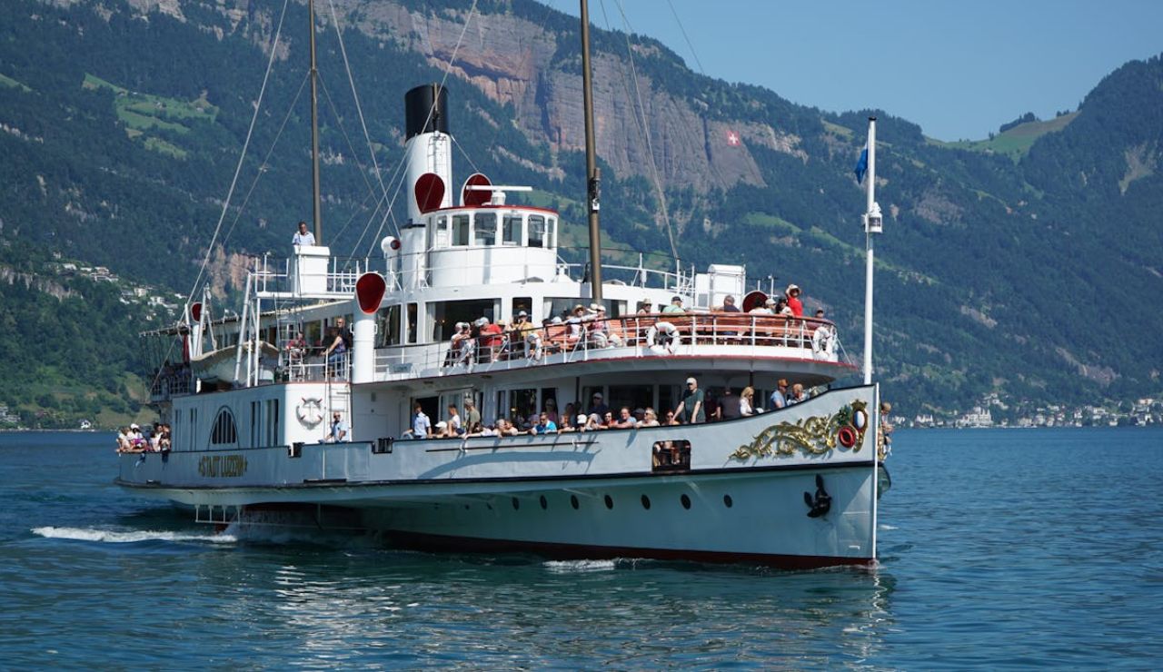 Scenic paddle steamer cruise on Lake Lucerne with mountains in the background.