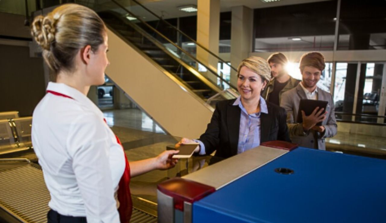 Guest services desk on a cruise ship with friendly staff assisting a passenger.