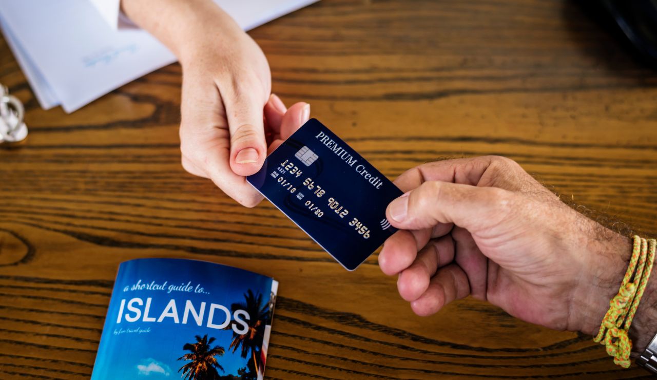 A hand holding a cruise loyalty program card near the check-in desk.