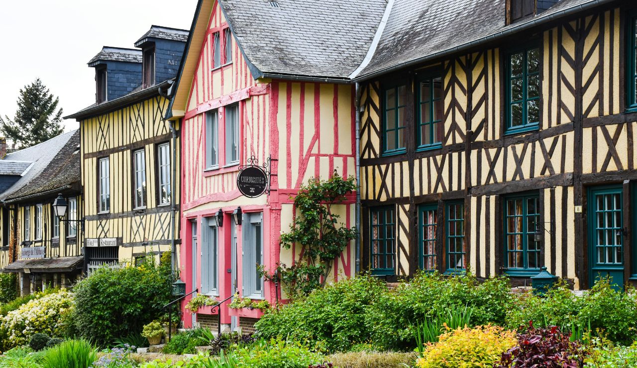 Pastel-colored timber houses in a circular lane lined with flowers in Eguisheim