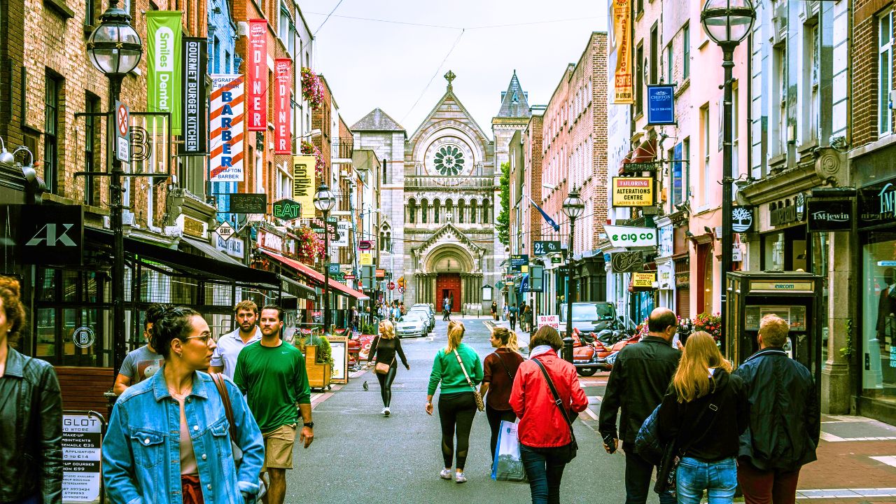 Travelers walking through a European city center with cafés and food markets