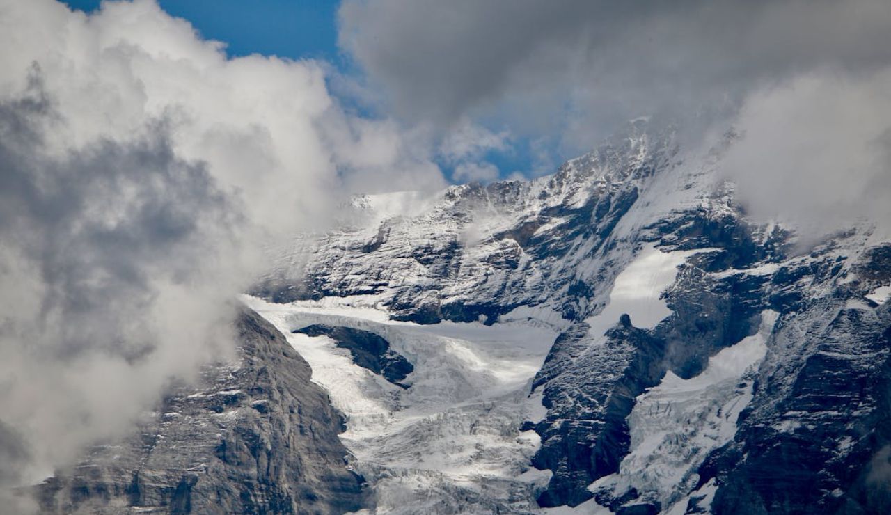 Snow-covered mountain peaks surrounded by clouds.