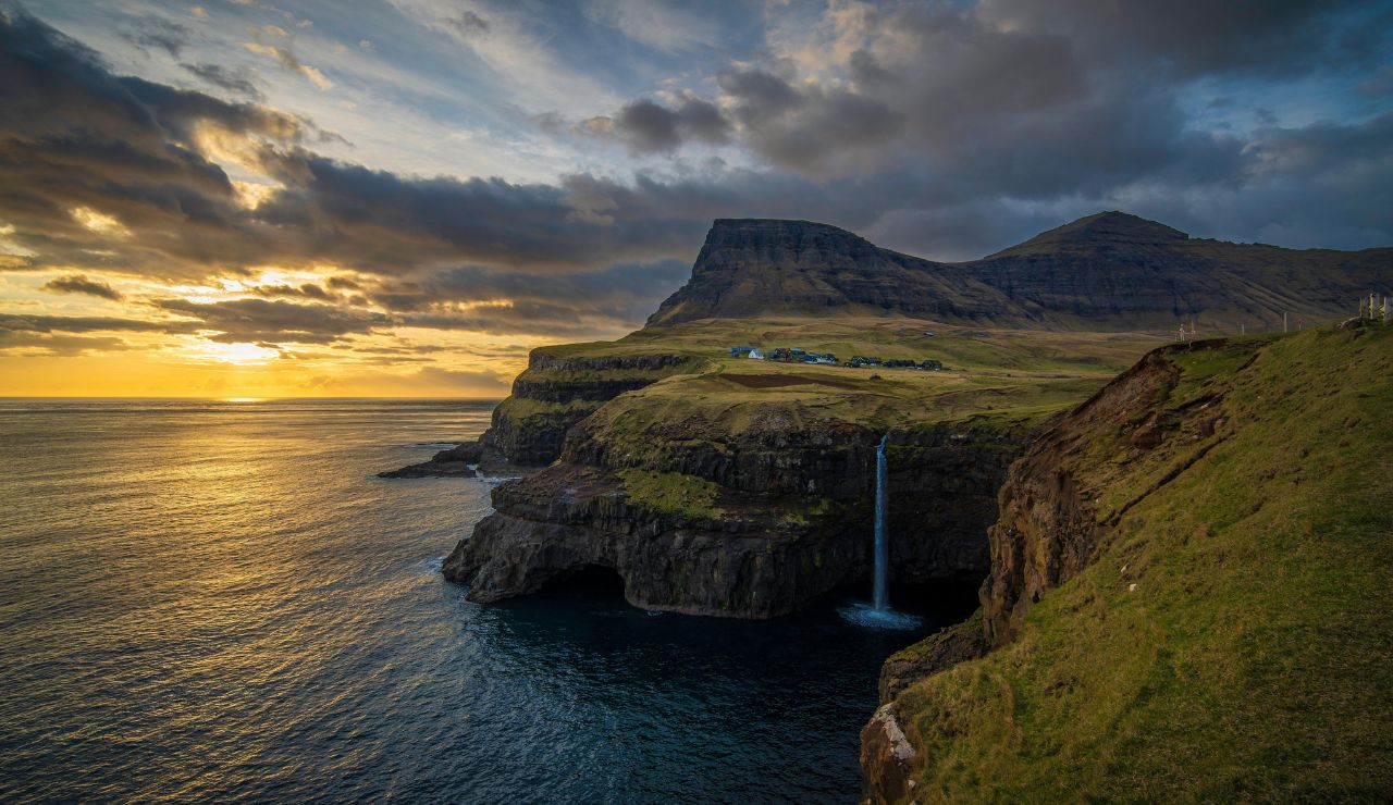 Faroe Islands cliffside with waterfall cascading into the Atlantic.
