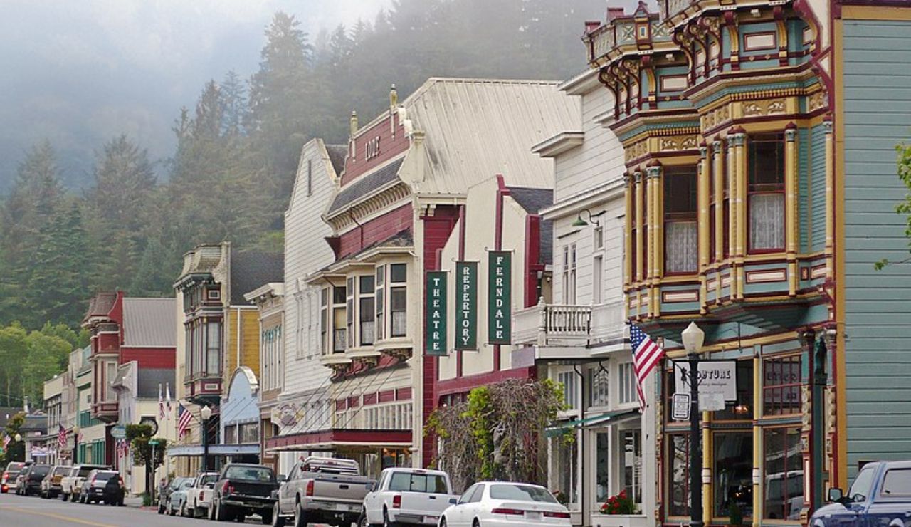 Colorful Victorian buildings line a quiet street in foggy Ferndale, California.