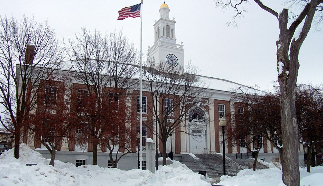 Historic red-brick courthouse with a clock tower, surrounded by snow-covered ground and leafless trees in winter.