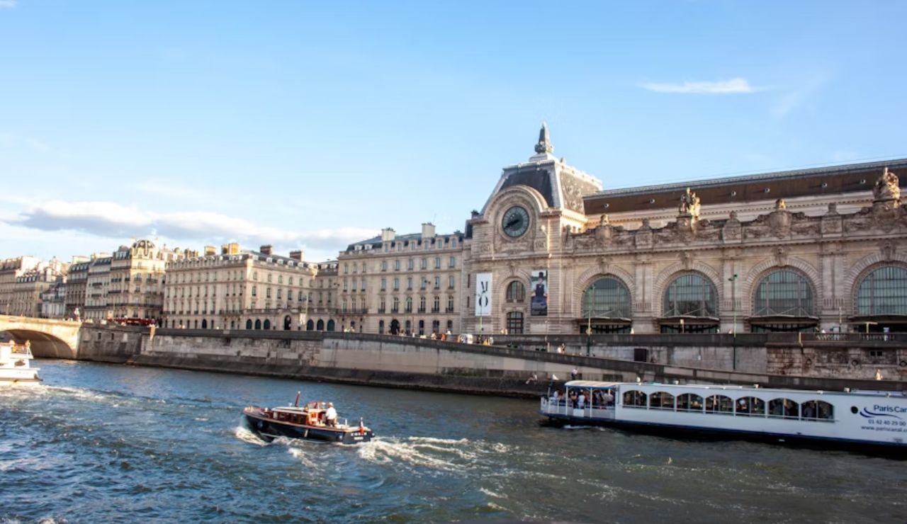 Tour boats cruising on the Seine River near Musée d'Orsay in Paris.