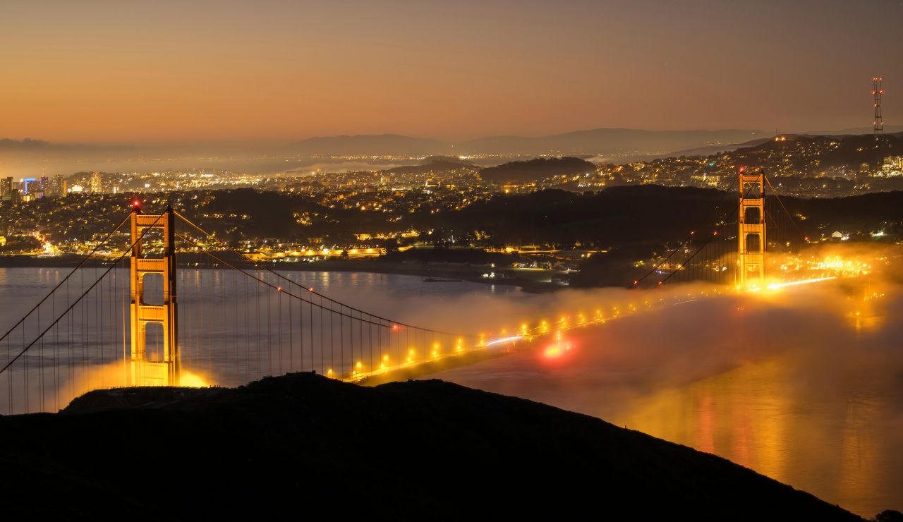 Golden Gate Bridge at sunset with fog rolling over the bay