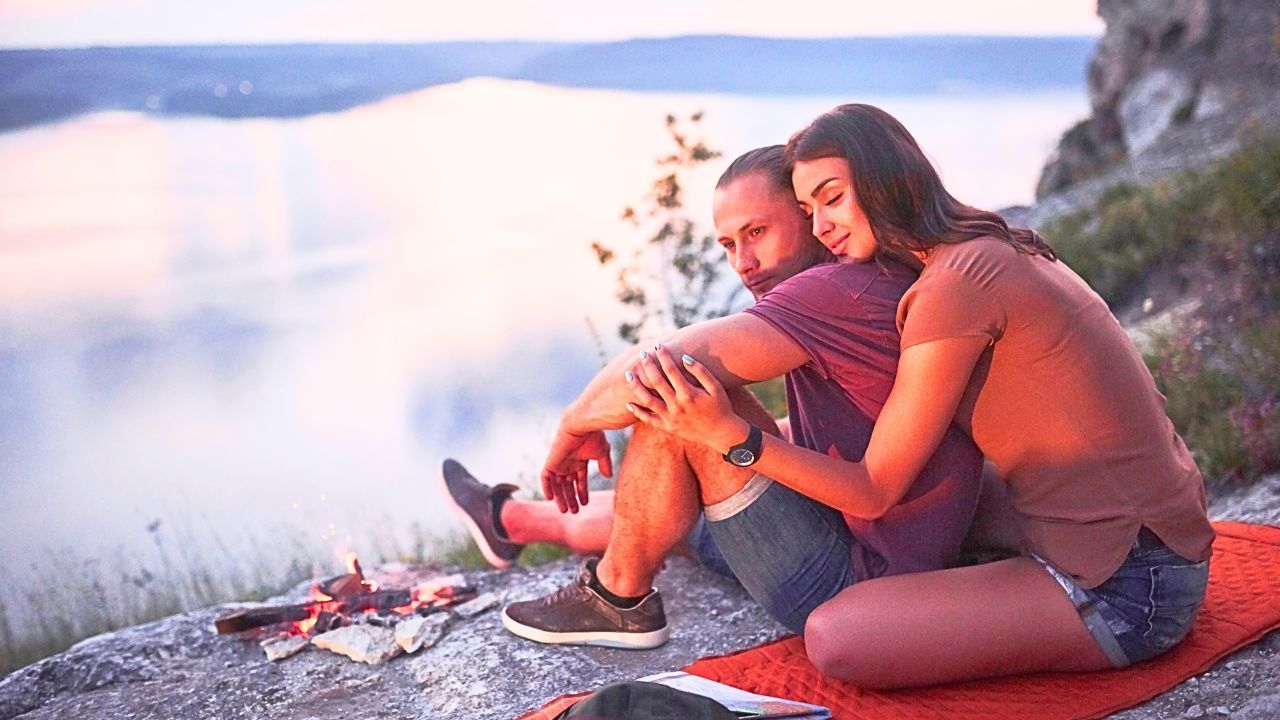 Couple sitting on the edge of the Grand Canyon at sunset