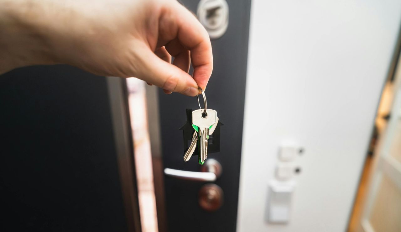 Traveler locking front door with suitcase outside