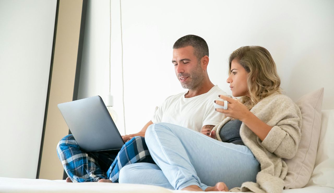 Couple having coffee in bed during morning light