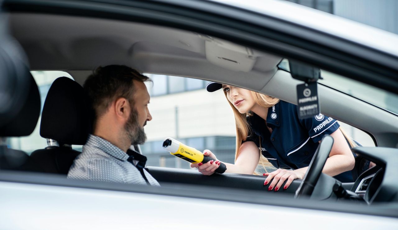 Police officer conducting a breathalyzer test on a driver.