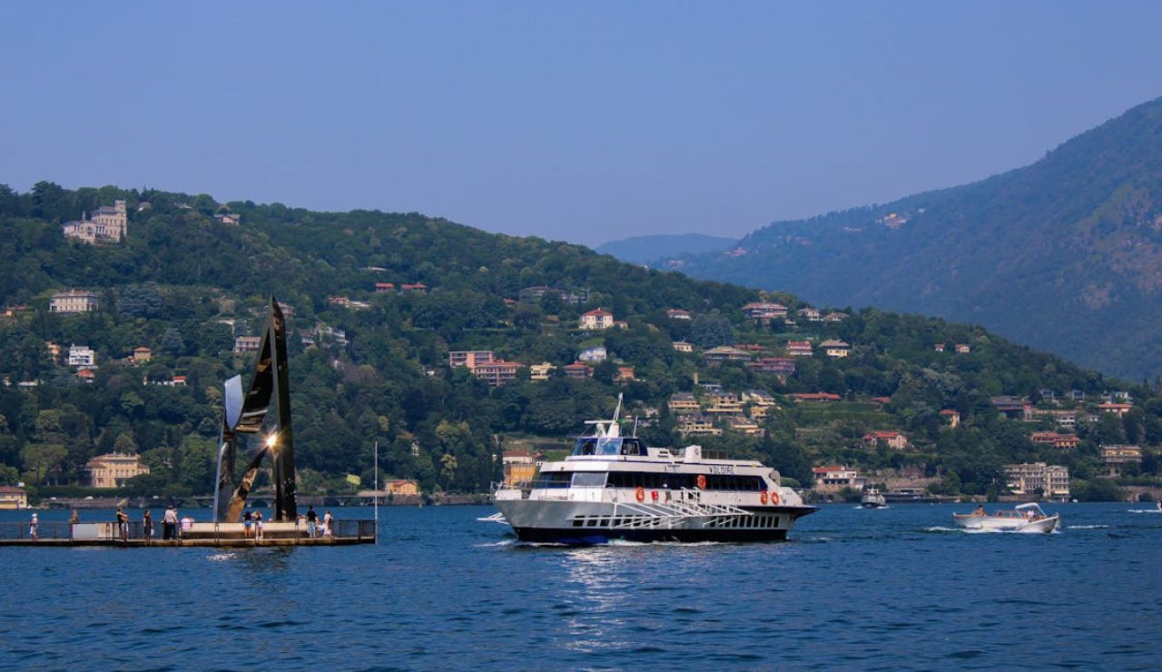 Tourist boat cruising on Lake Como with hillside villas in the background.