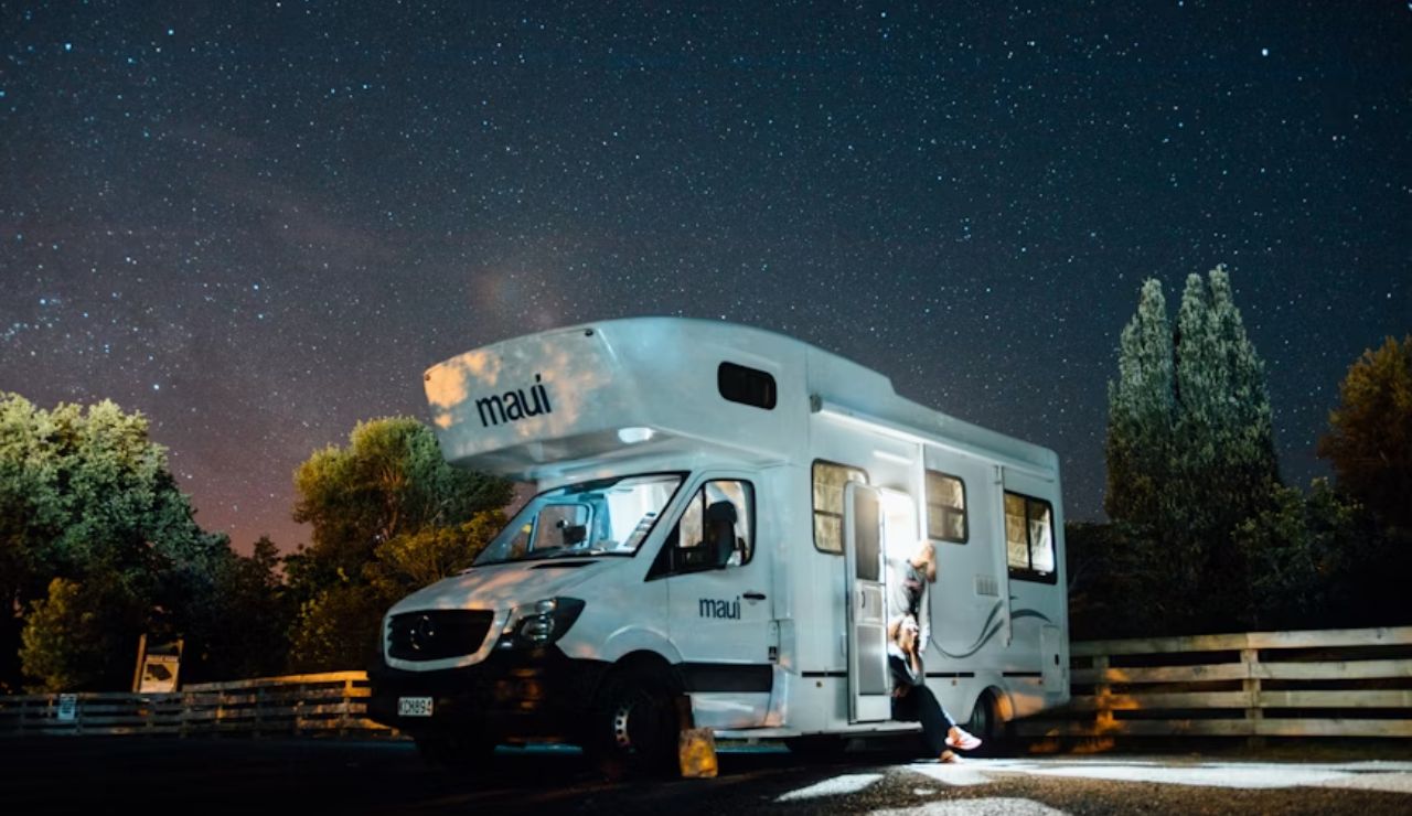 Person stepping out of RV under a starry night sky, capturing the magic of RV life.