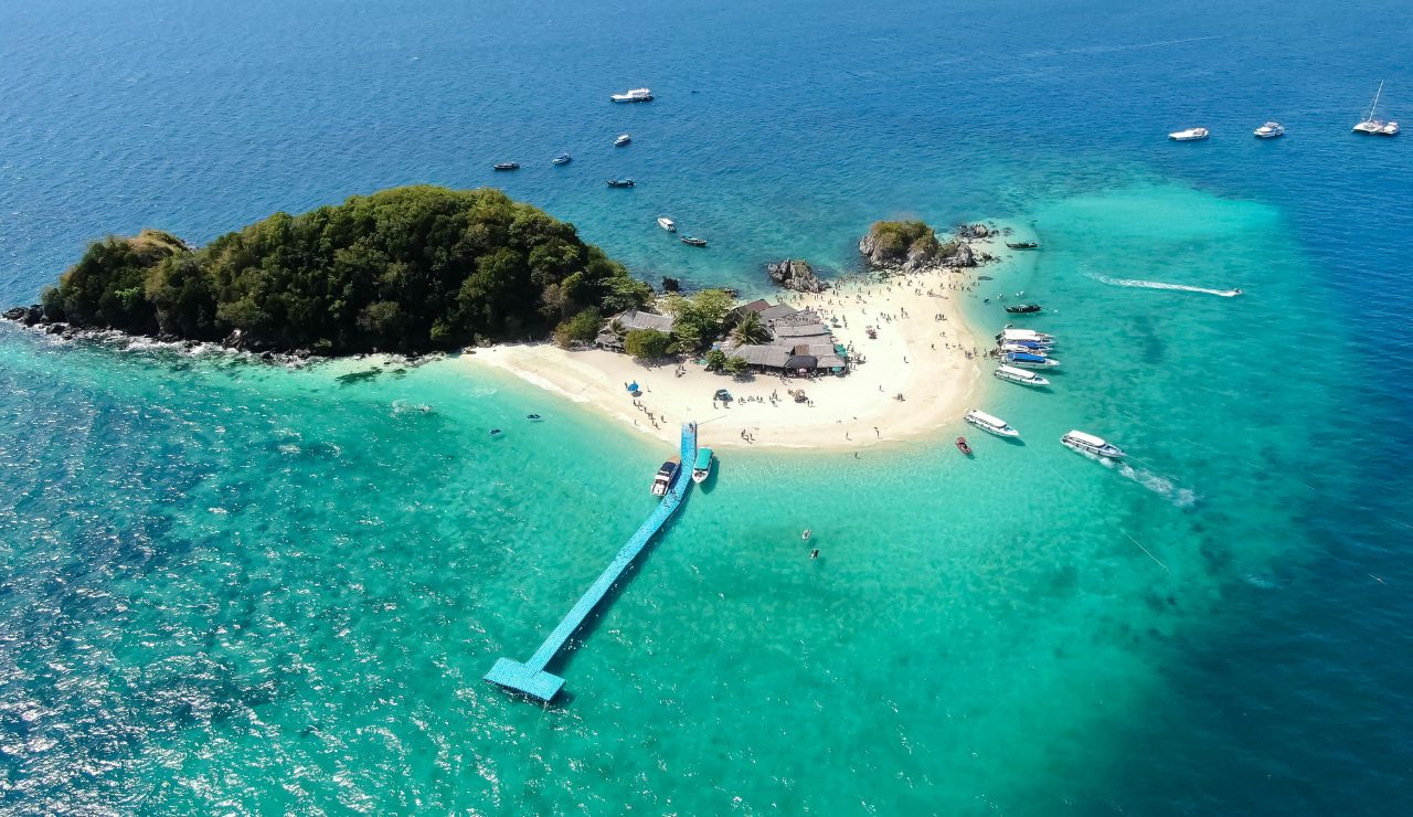 Clear water, white sand, and small islands in the distance.