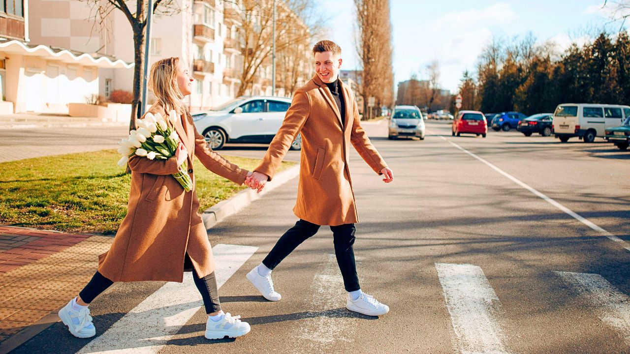 Couple walking hand-in-hand through a historic street in Latin America