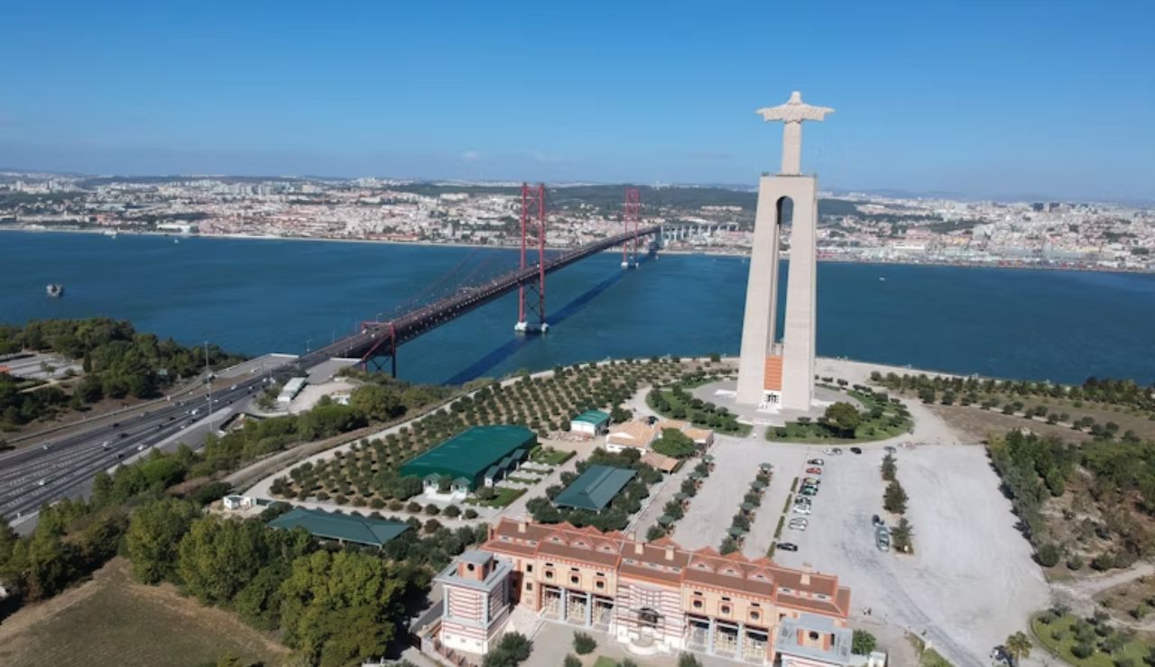 Aerial view of the Christ the King statue overlooking the 25 de Abril Bridge and the Tagus River in Lisbon, Portugal.