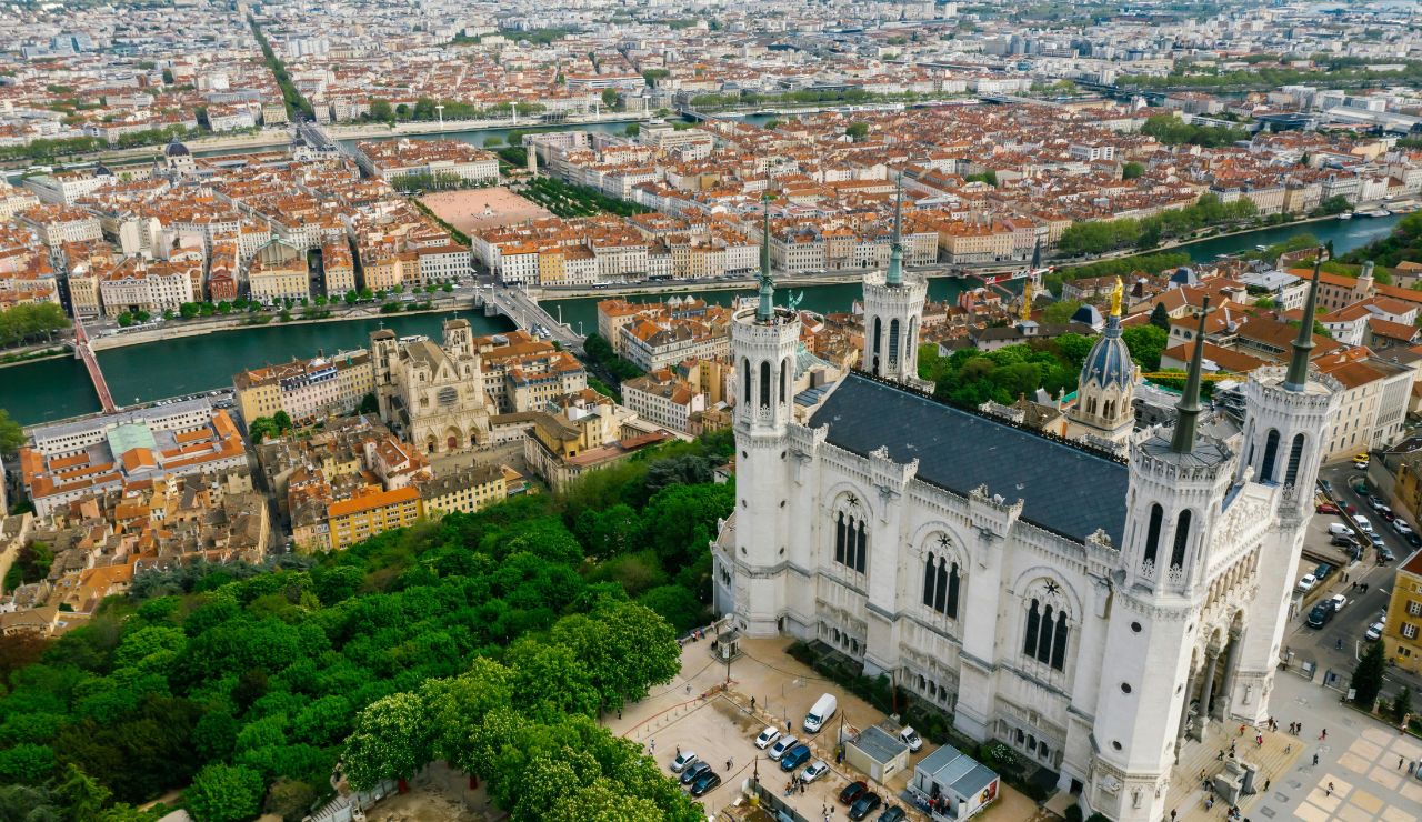Aerial view of Lyon, France, featuring the Basilica of Notre-Dame de Fourvière and the Saône River surrounded by historic city buildings.