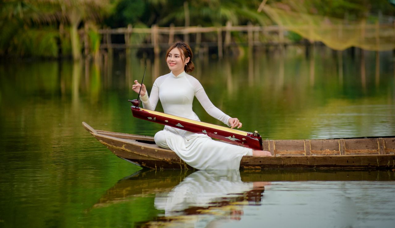 A wooden boat floating along the Mekong River with green jungle in the background.
