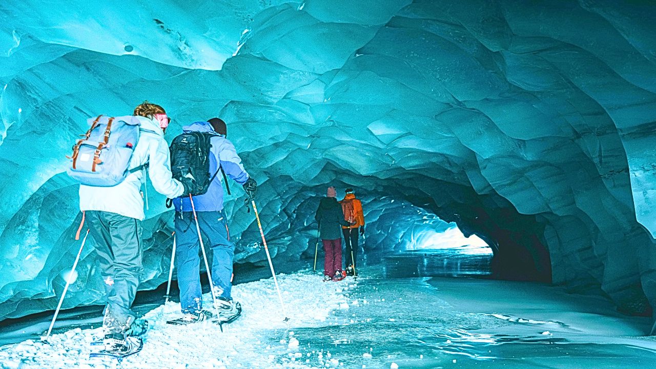 Fewe people going inside the glowing blue Mendenhall Ice Caves in Alaska