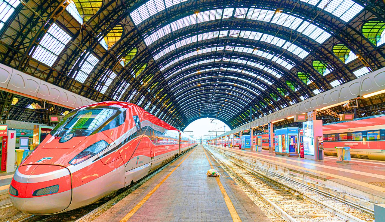 Entrance of Milan Central Station with sculptures and monumental arches.