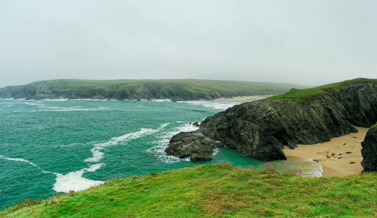 Dramatic cliffs and narrow rocky cove with turquoise waves.