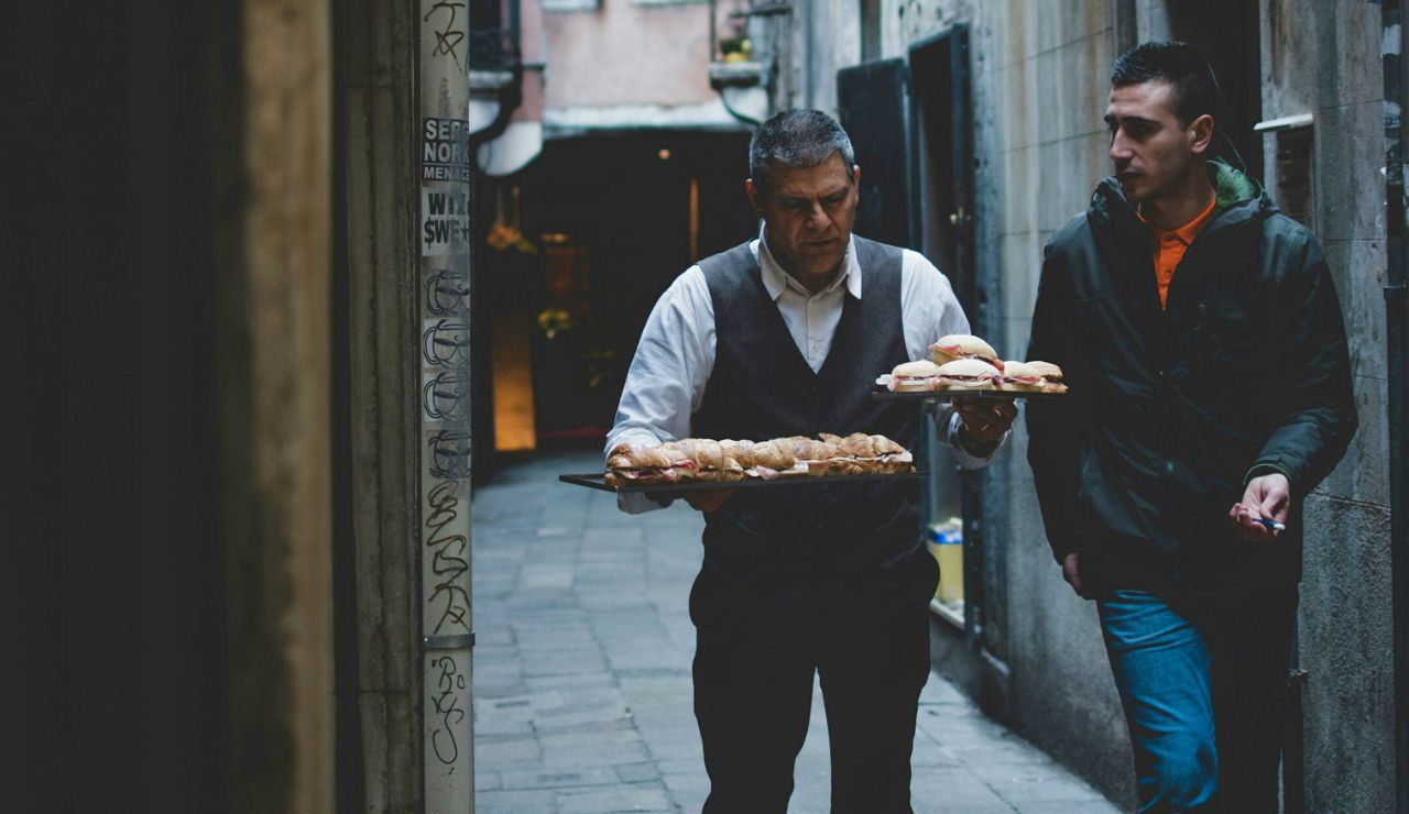 Street vendor serving pizza in a narrow alley of Naples