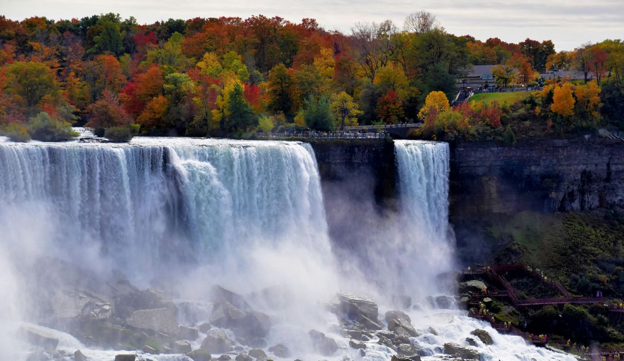 Majestic view of Niagara Falls with mist rising and boat below.