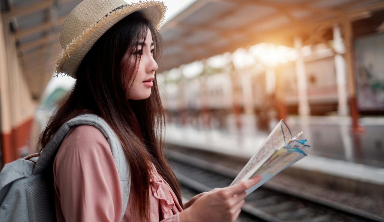 Tourist looking at a packed guidebook schedule with a stressed face