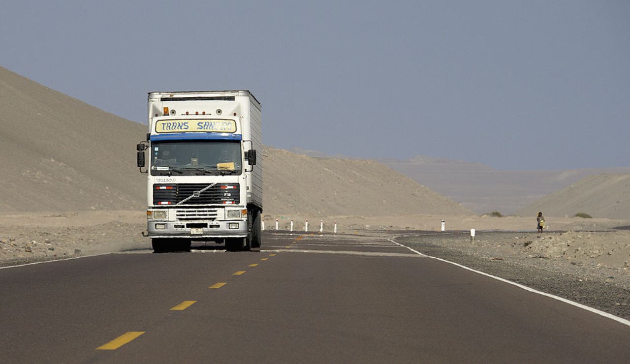 Truck on the Pan-American Highway in Peru, cutting through arid desert hills.