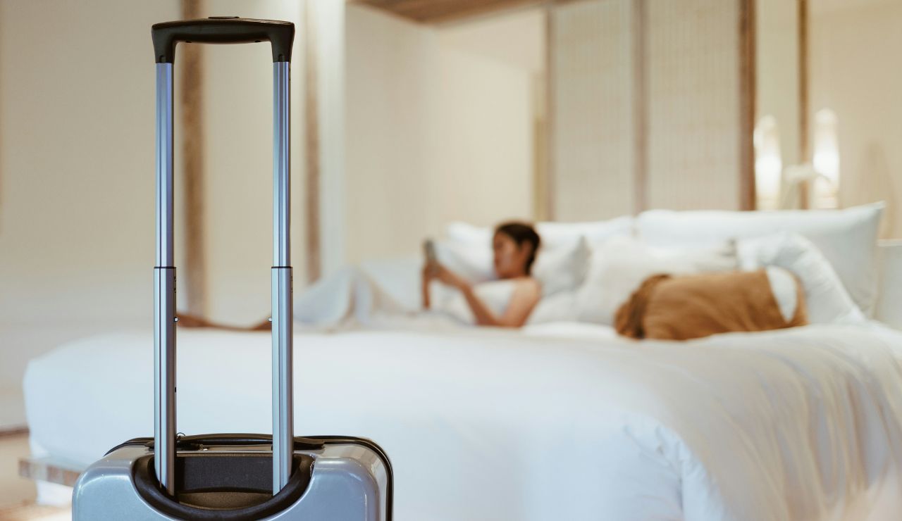 Traveler adjusting bedtime alarm on phone before trip