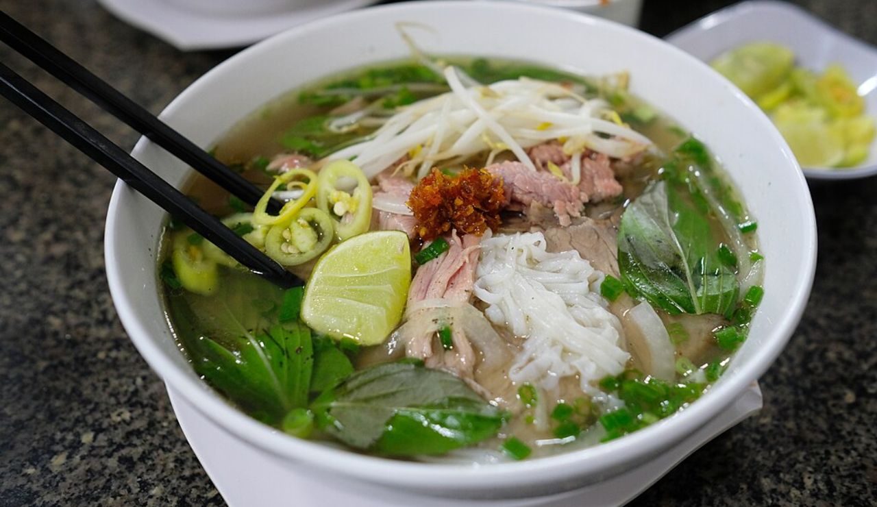 Bowl of Vietnamese phở with beef, herbs, lime, and chili.