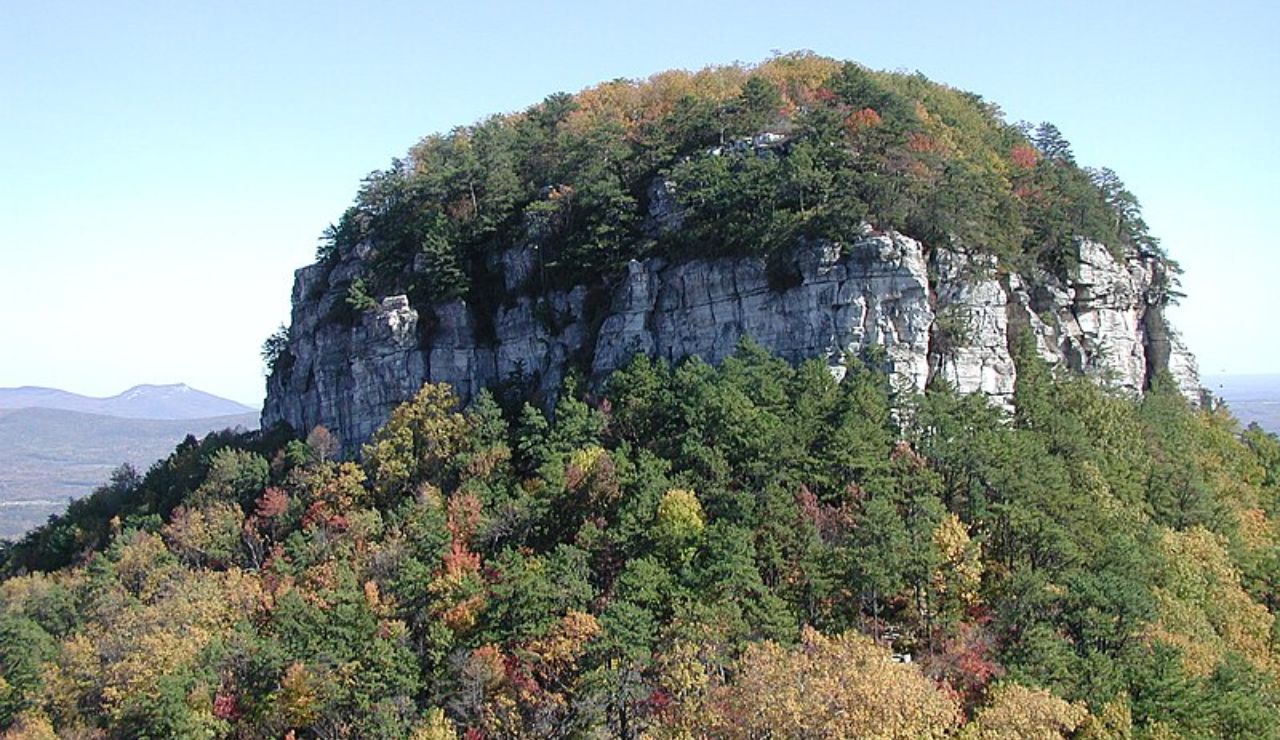 Pilot Mountain in North Carolina surrounded by colorful autumn foliage.