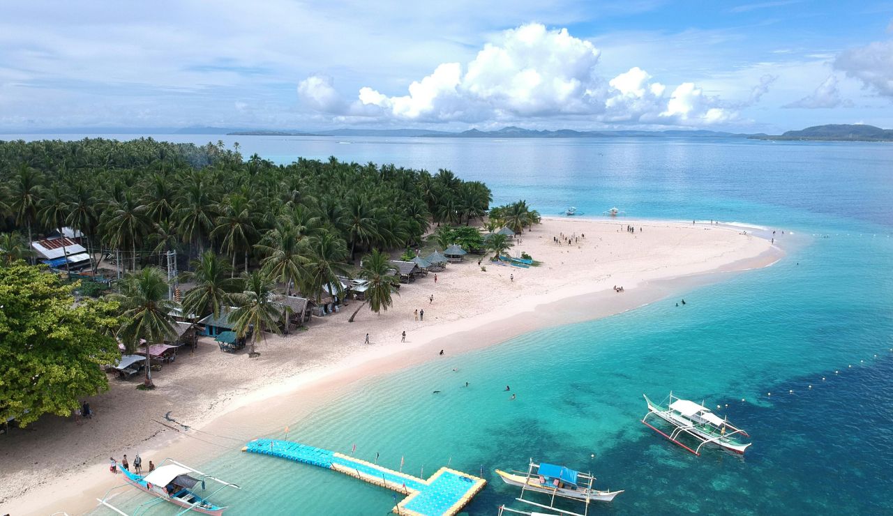 Tranquil palm-fringed coast and wooden boats on Pingelap Atoll.